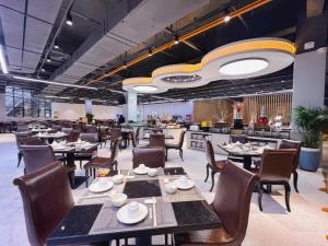 a dining room with tables and chairs and a restaurant at Shenzhen Jin Mao Yuan Hotel in Shenzhen