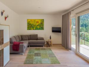 a living room with a couch and a tv at Walser Lodge in Mittelberg