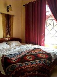 a bedroom with a bed with a red curtain and a window at BONNIE HOMESTAY Mui Ne in Mui Ne +159 photos