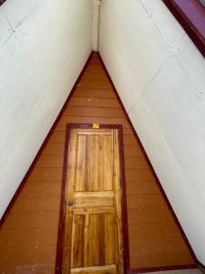 a small wooden door in the middle of a attic at Mountain View dormitory in Ban Sôphoun