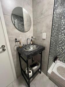 ein Badezimmer mit Waschbecken, Spiegel und Dusche in der Unterkunft Apartamento estudio Flor de Lis in Salta