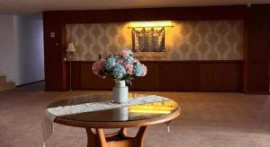 a vase of flowers on a table in a room at Hotel Mekkah Banda Aceh in Banda Aceh