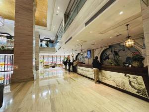泉州市にあるSoutheast Peninsula Hotel Quanzhouの人々が立っている建物のロビー