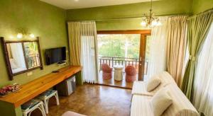 a living room with a couch and a television at Baan Parinda (Pompom Home) in Pran Buri