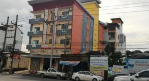 a large building with cars parked in front of it at V-House Hotel in Trang