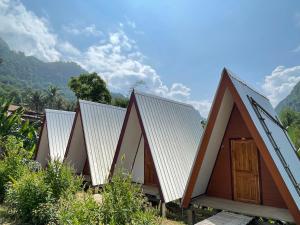 a row of triangular houses with mountains in the background at Mountain View dormitory in Ban Sôphoun