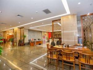 a dining room with a table and chairs in a building at Auspicious Hotel in Zhongshan