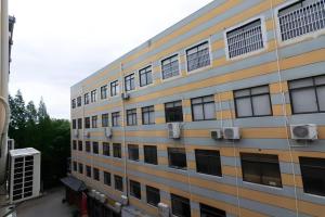 a tall building with windows on the side of it at IU Hotel Shanghai Jiaotong University Jiangchuan Road Metro Station in Shanghai