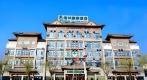 a large building with a sign on top of it at GreenTree Inn Shandong Yuncheng Ximen Street Songjiang Kung Fu School Business Hotel in Yuncheng