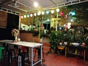 a restaurant with tables and plants in a room at BONNIE HOMESTAY Mui Ne in Mui Ne
