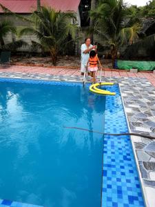 a man and a child playing in the water in a pool at BONNIE HOMESTAY Mui Ne in Mui Ne