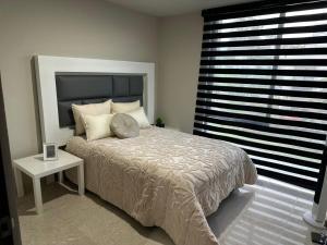 ein Schlafzimmer mit einem Bett und einem Tisch und einem Fenster in der Unterkunft Residencial Santa Anita in San Agustín