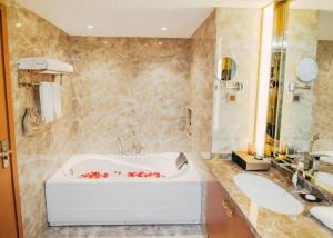 une salle de bain avec une baignoire et un lavabo dans l'établissement Bati Holiday Hotel, à Zhongshan 138 autres photos