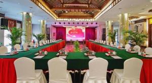 Un gran salón de banquetes con una mesa larga y sillas blancas. en Tiantai Hotel,  139 fotos más