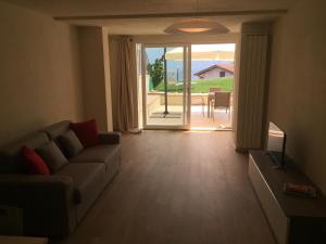 Una sala de estar con un sofá y una puerta corrediza de vidrio. en Anna Apartments, en Castro
