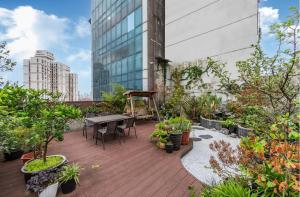 a balcony with a table and chairs and plants at Shanghai Wujiaochang Dabaishu Orange Crystal Hotel in Shanghai