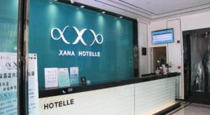a sign for a hotel in a building at Xana Hotelle Neijiang City Center Branch in Neijiang