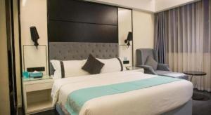 a hotel room with a large bed and a chair at Xana Hotelle Neijiang City Center Branch in Neijiang +124 photos