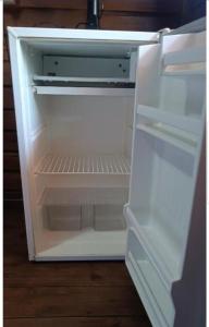an empty refrigerator with its door open in a kitchen at Brayan`s House in Ilha do Mel