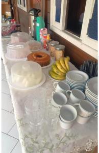 a table with plates and cups and bananas on it at Brayan`s House in Ilha do Mel +15 photos