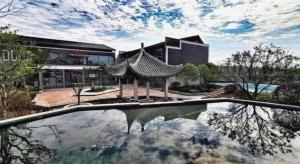 un edificio con reflejo en una piscina de agua en Tiantai He hotel, en Tiantai