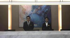 上海市にあるMagnotel Hotel Shanghai Railway Station Magnolia Plazaの二人の男が襟の前に座っている