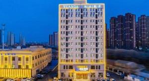 a tall white building in a city at night at Jinjiang Inn Select Changchun Yuanda Street in Changchun