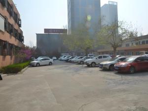 a bunch of cars parked in a parking lot at GreenTree Inn WeiFang QingZhou Middle HaiDai Road Electric Power Shell in Weifang