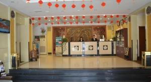 a restaurant with two people standing at a counter at GreenTree Inn WeiFang QingZhou Middle HaiDai Road Electric Power Shell in Weifang