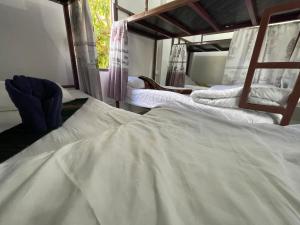 a group of three white beds in a room at Mountain View dormitory in Ban Sôphoun