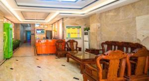 a dining room with chairs and a table in a room at PAI Hotel·Huazhou Bus Terminal in Maoming