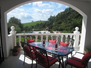 patio con mesa de cristal y sillas en el balcón en Villa La Recalada en Estepona