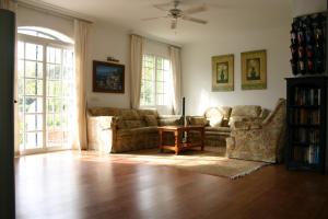 a living room with two couches and a table at Villa La Recalada in Estepona