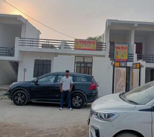 a man standing next to a car at a gas station at Mamta Home Stay in Ayodhya