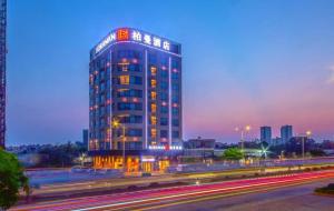 a tall building with lights on in a city at night at Borrman Hotel Zhanjiang Xuwen Port Terminal in Xuwen