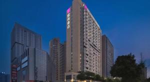 a tall building with a sign on top of it at Echarm Hotel Changsha High-speed Railway Station in Changsha