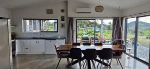 a kitchen and dining room with a table and chairs at Valley Views Near City & Coast in Tahere
