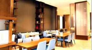 a restaurant with wooden tables and white chairs at Echeng Hotel Sanming City Government RT-Mart in Sanming