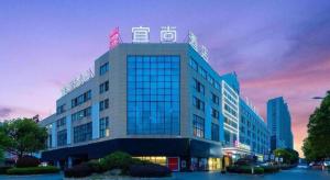 a building with a sign on the top of it at Echarm Hotel Yingshang High-speed Railway Station Wuzhou Wanhui Plaza in Fuyang