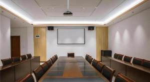 a conference room with chairs and a projection screen at Borrman Hotel Qianjiang High-speed Railway Station Lobster City in Qianjiang