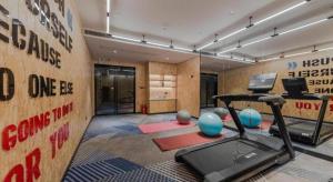 a room with a gym with a treadmill and weights at Borrman Hotel Qianjiang High-speed Railway Station Lobster City in Qianjiang