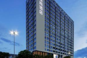 a tall building with a sign on the side of it at Echarm Hotel Nanning Chaoyang Square River View in Nanning