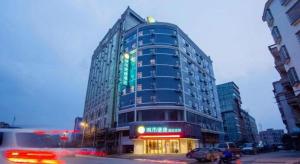 ein hohes Gebäude auf einer Stadtstraße bei Nacht in der Unterkunft City Comfort Inn Fangcheng Qunxing Avenue in Fangchenggang