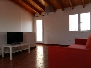 a living room with a red couch and a tv at Can Mayol in Alaró