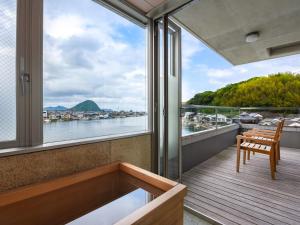 a balcony with a bench and a view of the water at 萩八景 雁嶋別荘 in Hagi