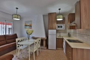 a kitchen and living room with a table and a couch at Apartamentos El Madroñal in Coto Rios