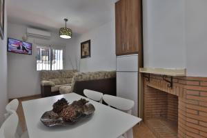 a kitchen and living room with a table and a fireplace at Apartamentos El Madroñal in Coto Rios