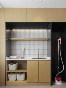 a kitchen with a sink and shelves with baskets at City Comfort Inn Nanchang Shuanggang Metro Station Finance University in Nanchang