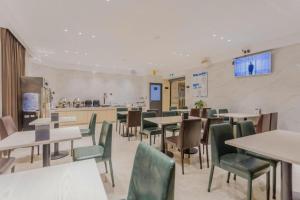 a restaurant with tables and chairs and a kitchen at City Comfort Inn Foshan Gaoming Huaying Square in Foshan
