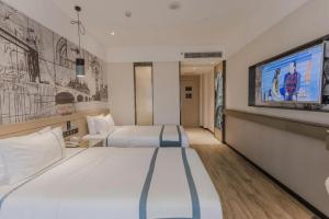 a hotel room with two beds and a tv at City Comfort Inn Foshan Gaoming Huaying Square in Foshan